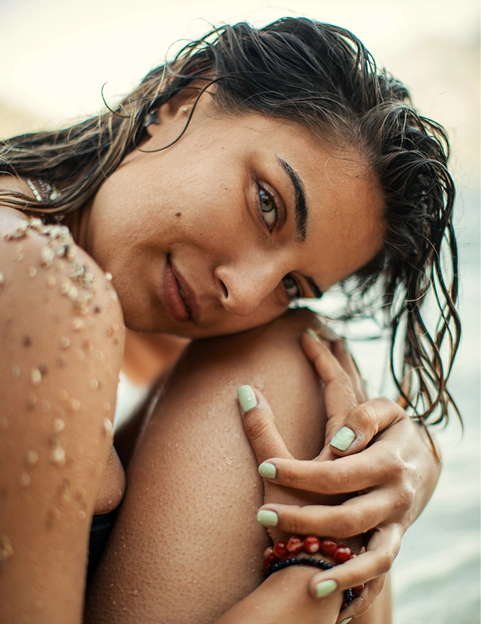 Woman with wet hair and natural makeup smiling at beach during golden hour sunset - Nasal spray in Newport Beach, CA
